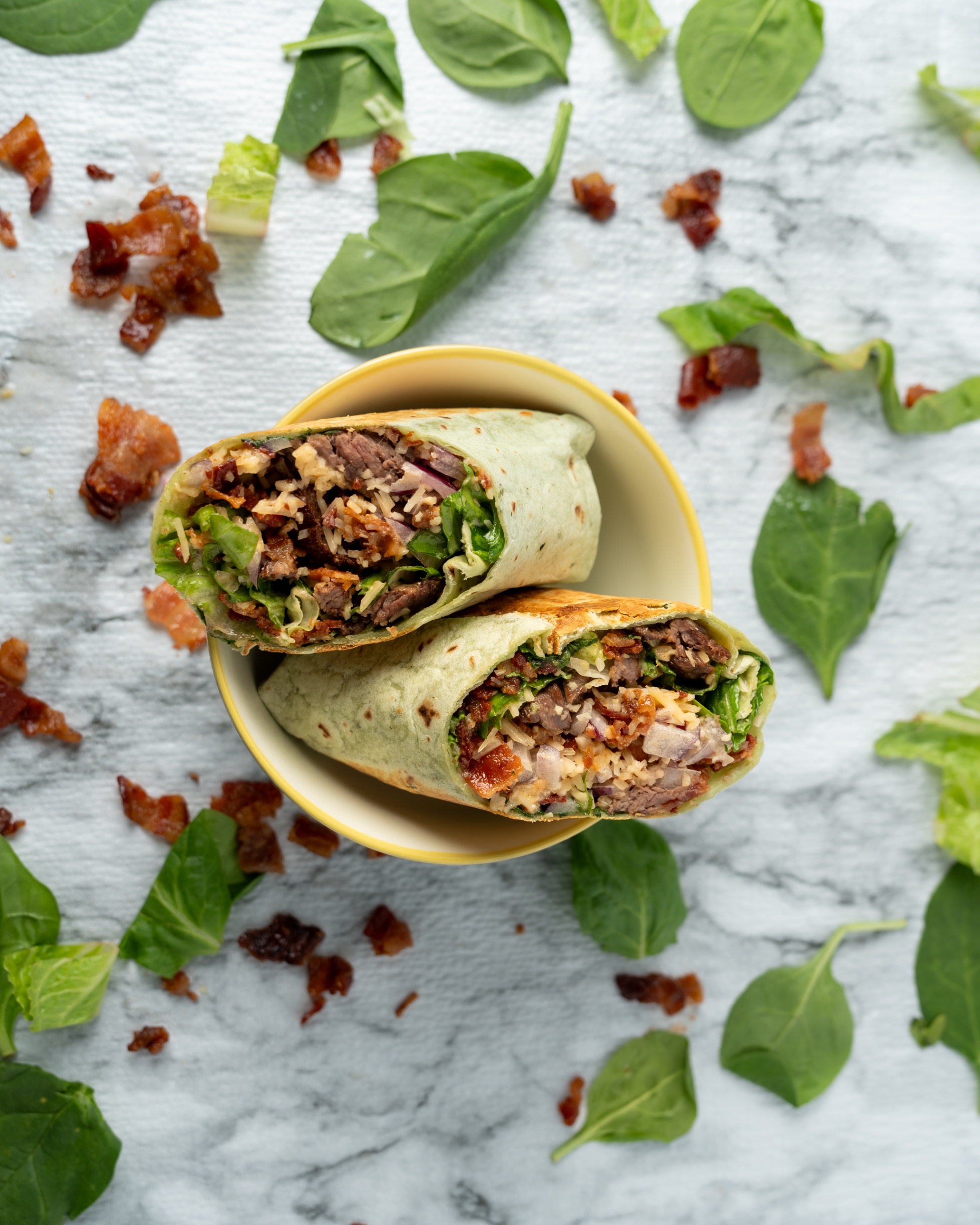 Un wrap de churrasco cortado a la mitad, servido en un bowl